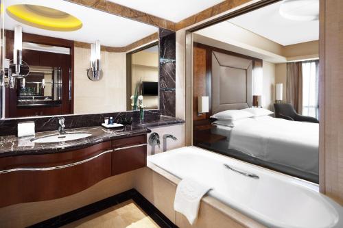 a bathroom with a bath tub and a bed at Sheraton Wenzhou Hotel in Wenzhou