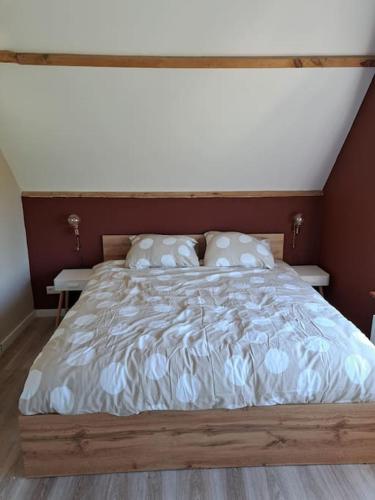 a bedroom with a large bed with white sheets and pillows at Family House Wakker in Eemnes