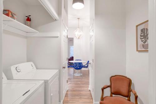 a white hallway with a table and a chair at Stars on State in the Heart of Downtown Historic District in Mobile