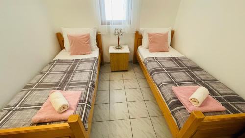 two twin beds in a small room with at Lovely apartments on the private Beach - island Korčula in Prizba