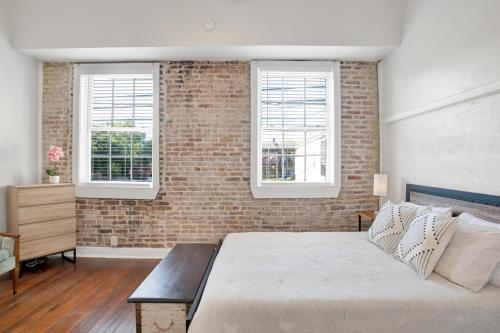 Un dormitorio con una pared de ladrillo y una cama en Stars on State in the Heart of Downtown Historic District, en Mobile