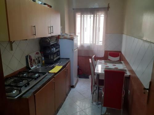 a kitchen with a stove and a table with chairs at Appartement Sidi Maarouf in Casablanca