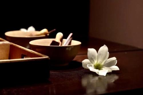 a white flower sitting on top of a wooden table at Le Palais Art Hotel Prague in Prague
