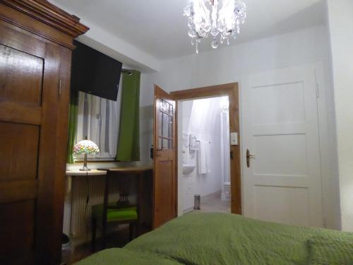 a bedroom with a bed and a chandelier at Pension Zur Rose in Weil am Rhein