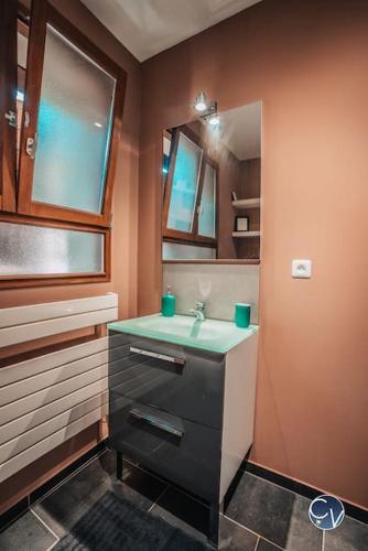 une salle de bain avec un lavabo et un miroir dans l'établissement Villa avec piscine privée et jardin en Ardèche, à Orgnac-lʼAven