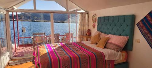 a bedroom with a bed with a view of the water at Uros Titicaca coila lodge in Puno