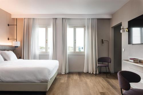 a hotel room with a bed and two windows at Ambasciatori Hotel Venice Mestre, Tapestry Collection by Hilton in Mestre