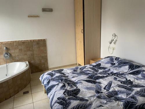 um quarto com uma cama e uma banheira em אושפיז דבורה ועופר em Sha'al