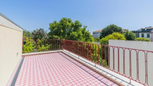 a balcony with a red metal fence and trees at Urban House Marquês by LovelyStay in Porto