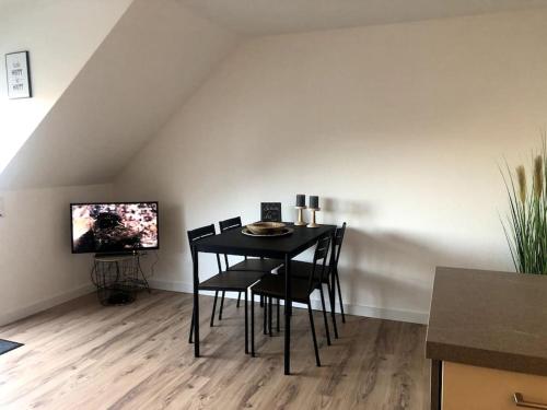 una sala da pranzo con tavolo, sedie e TV di Central Hub Kassel City a Kassel