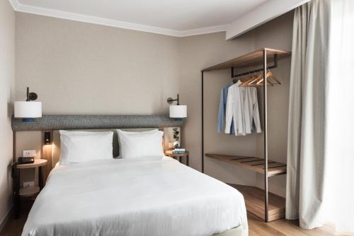 a bedroom with a large bed and a closet at Ambasciatori Hotel Venice Mestre, Tapestry Collection by Hilton in Mestre