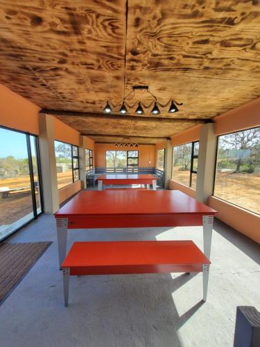 un grande tavolo rosso in una stanza con finestre di Peace Haven @ Windfarm Accommodation a Yzerfontein