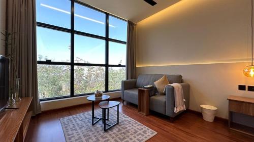 uma sala de estar com um sofá e janelas grandes em مساكن خاصة بتصميم فندقي ووصول ذاتي em Taif