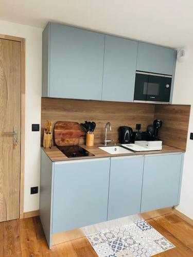 une cuisine avec des armoires blanches et un évier dans l'établissement Domaine l’Ariondaz 1650, Charmant T2, à Courchevel