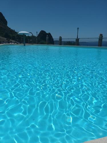 una piscina di acqua blu con un cielo blu sullo sfondo di La Villa Tanca Piras a Nebida