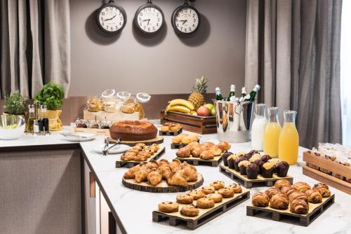 a buffet with many different types of pastries and clocks at Ambasciatori Hotel Venice Mestre, Tapestry Collection by Hilton in Mestre