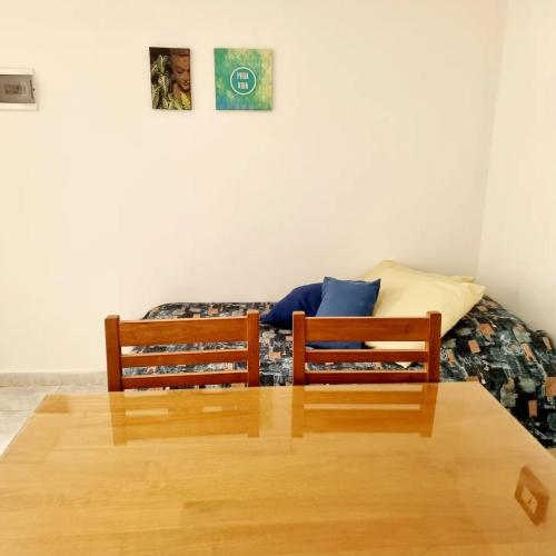 two wooden chairs sitting in a room with a bed at Dpto MARINE in Caleta Olivia