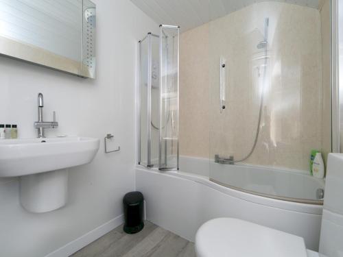 a bathroom with a shower and a sink and a toilet at Pass the Keys Spacious Cottage in central Benllech with parking in Benllech