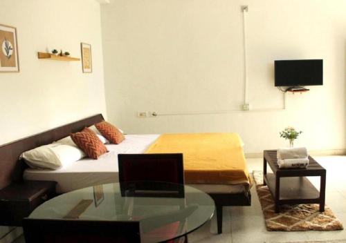 a living room with a bed and a glass table at Noor Plaza in Angamali