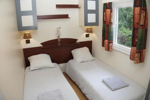 1 dormitorio con 2 camas y ventana en Les chalets de Gaillac en Gaillac