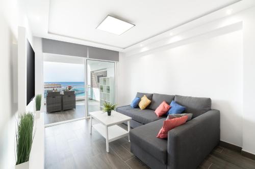 een woonkamer met een bank en uitzicht op de oceaan bij TuristMar - Fabuloso apartamento con vista de lujo in Salou