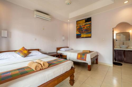 a hotel room with two beds and a sink at Suarsena Ubud in Ubud