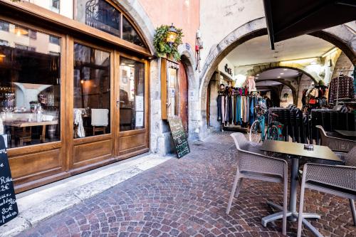 un restaurant avec des tables et des chaises dans une rue dans l'établissement Hibou vieille ville charme de l ancien, à Annecy