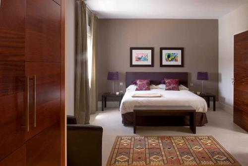 a bedroom with a bed and two tables and a door at Beautiful Villa Ambar in Puerto del Carmen