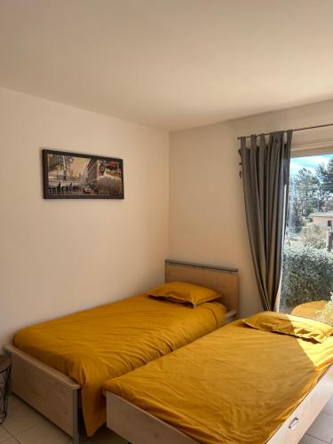 two beds in a room with a window at villa Peylon 2 in Flayosc