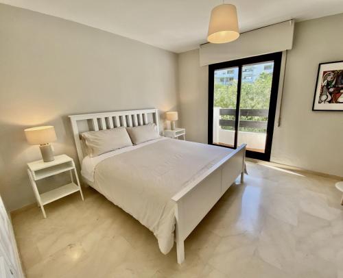 Un dormitorio con una gran cama blanca y una ventana en Escape to Serenity - 3 Bedroom Townhouse by the Sea!, en Marbella