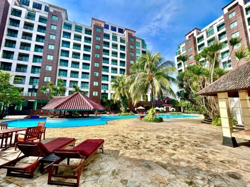 a resort with a pool and chairs and buildings at Kristal Hotel Jakarta in Jakarta