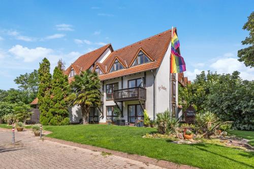 a house with a flag on the lawn at Besilima Apartments Deidesheim - zentral & ruhig am Kurpark in Deidesheim