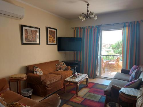 uma sala de estar com um sofá e uma televisão de ecrã plano em Marina Wadi Degla Villa Duplex 4 Bedrooms em Ain Sokhna