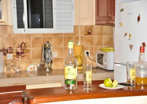 una bottiglia di vino e due bicchieri sul bancone della cucina di L'Escapade Soufrière a Saint-Claude