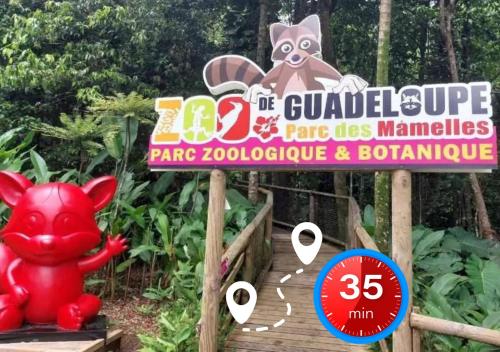 L'Escapade Soufrière في سانت-كلود: لافتة لحديقة حيوانات عليها خنزير على ممشى خشبي