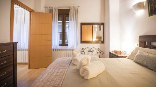 1 dormitorio con 1 cama con toallas en Apartamento Alfileritos 14 by Toledo AP en Toledo