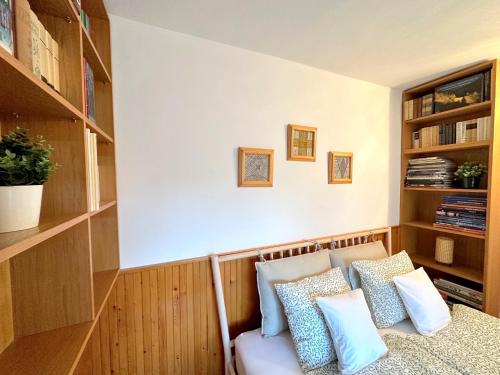 a room with a bed with pillows and shelves at Tiétek a HÁZ in Mogyoród