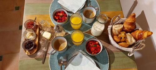 a table with a plate of breakfast foods and drinks at La maison WISTERIA in Saint-Pantaléon-les-Vignes