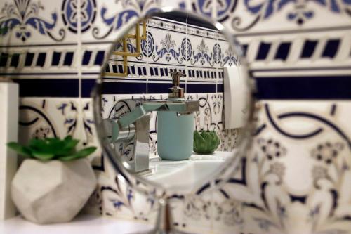 a bathroom with blue and white tiles and a mirror at La maison WISTERIA in Saint-Pantaléon-les-Vignes