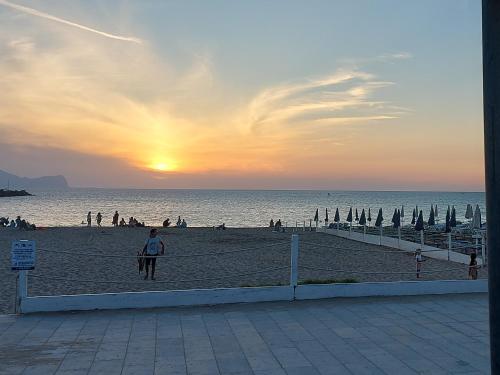 a person standing on a beach at sunset at Villa Torre Magaggiari in Cinisi