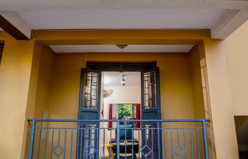 a house with a blue door and yellow walls at One bedroom apartment at Nalya in Kampala