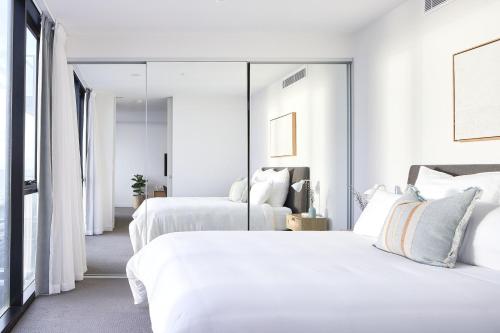 a bedroom with two beds and a large mirror at The Swell in Newcastle