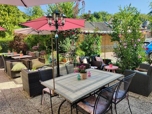 a table with a pink umbrella on a patio at Hotel B&B LeLa in Valkenburg