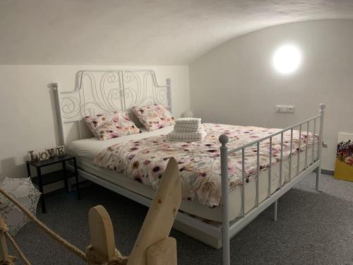 - une chambre dotée d'un lit blanc avec des draps et des oreillers roses dans l'établissement Apartmán Charmant, à Kroměříž