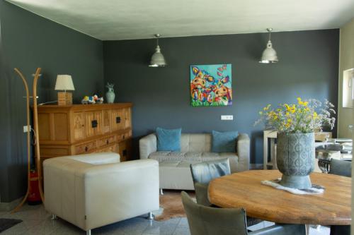 a living room with a couch and a table at Bed and Breakfast Lindershoeve Bergeijk in Bergeijk