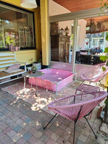a pink bed on a patio with two chairs at Hotel B&B LeLa in Valkenburg