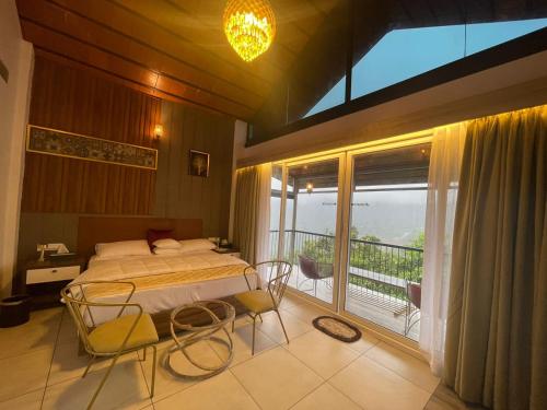 KakkadampoyilにあるBoulevard Resortsのベッドルーム(ベッド1台付)、バルコニーが備わります。