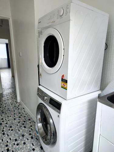 a washer and dryer in a kitchen with at PROMO!!! 2-Bedroom Home Near Airport, Train Station! in Melbourne