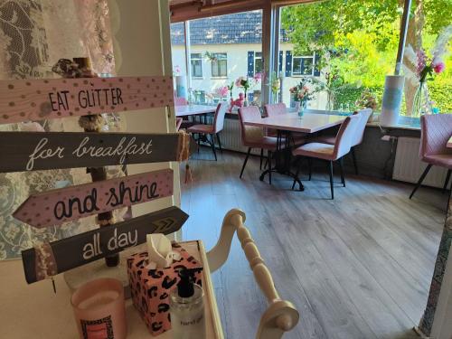 a restaurant with a table and chairs and a sign at Hotel B&B LeLa in Valkenburg