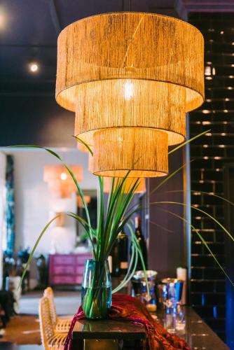 a lamp on a table with a plant in a vase at La Fontaine Boutique Hotel by The Oyster Collection in Franschhoek
